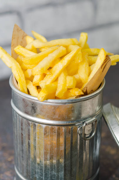 istock French fries in metallic basket isolated on rustic background 1250119543