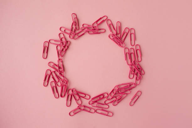 istock Scattered pink paper clips. Pink background. Flatlay. 1250123659