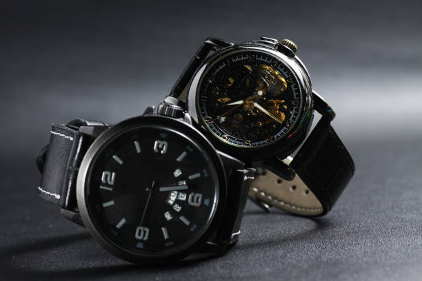 un reloj de pulsera automático negro de cuerda automática con diseño de esfera sekeleton transparente y un reloj negro accionado por batería - watchmaking fotografías e imágenes de stock