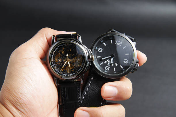 un reloj de pulsera automático negro de cuerda automática con diseño de esfera sekeleton transparente y un reloj negro accionado por batería - watchmaking fotografías e imágenes de stock
