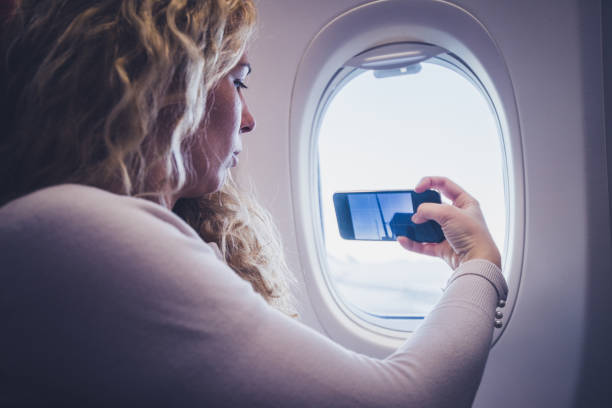 istock Young woman taking a picture from an airplane. 1250133248