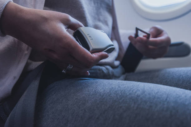 istock Female passenger fastening seat belt while sitting on the airplane for safe flight. 1250133357