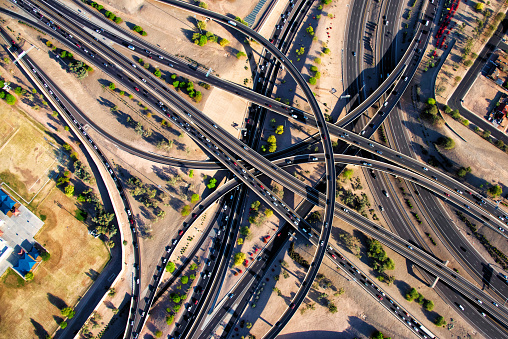 Directly over a interstate freeway interchange in the Phoenix, metropolitan area on a warm evening during rush-hour.