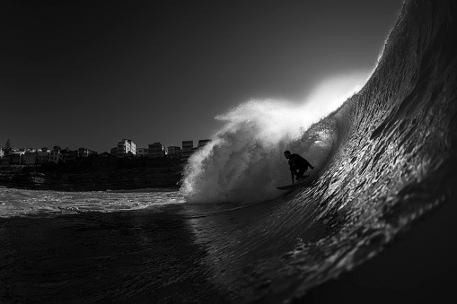 Sydney, Australia - May 10 2020: Black and White photo of a surfer surfing at Tamarama Beach, Sydney Australia
