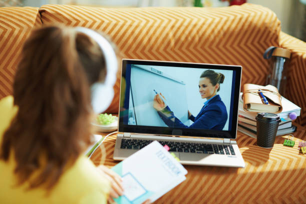 istock woman with white headphones and textbook using online school 1250137873