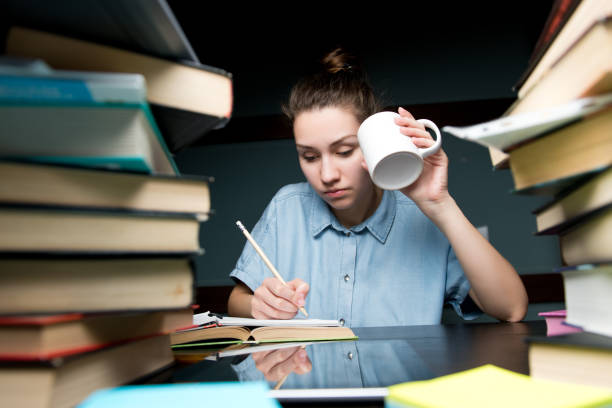 istock A student writes knowledge in a notebook and drinks coffee in the late evening 1250144149