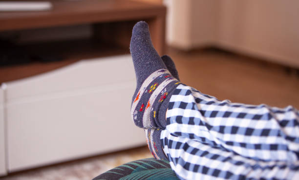 istock woman watching tv with feet on sofa, 1250146153