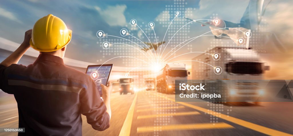 Transport and logistic concept, Manager and engineer checking and controlling logistic network distribution and data on tablet for logistic Import export on motorway background Freight Transportation Stock Photo