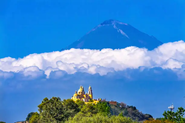 Colorful Yellow Iglesia de Nuestra Senora de los Remedios Our Lady of Remedies Church Volcano Mt, Popocatepetl Cholula Puebla Mexico. Church built 1500s