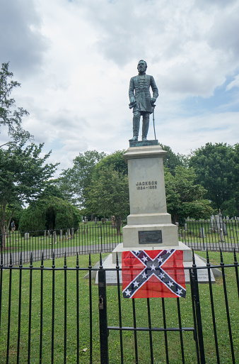 Lexington, Va, USA, June 14: Confederate general Stonewall Jackson grave and statue with a Confederate flag on the rail