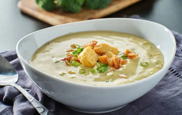 broccoli cheddar soup with croutons bacon and scallions close up