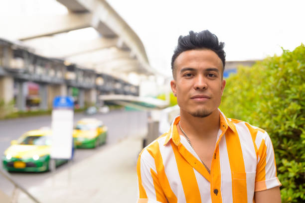 Portrait of young handsome multi ethnic man in the city streets outdoors
