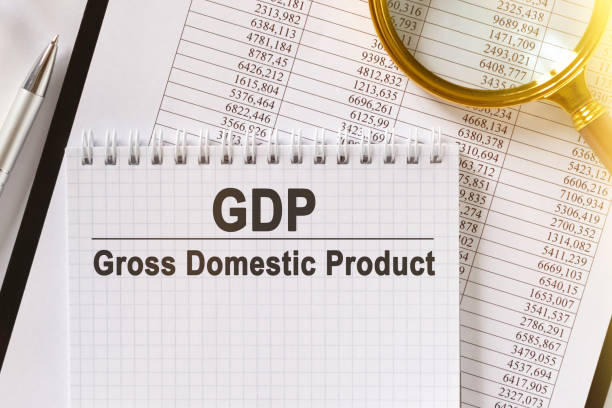 istock On the table are financial reports, a pen, a magnifying glass and a notebook with the inscription - GDP. 1250170433