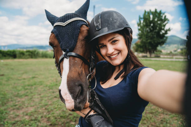 pov mening van een jonge volwassen vrouw terwijl zij een selfie met haar paard neemt - gekke paarden stockfoto's en -beelden
