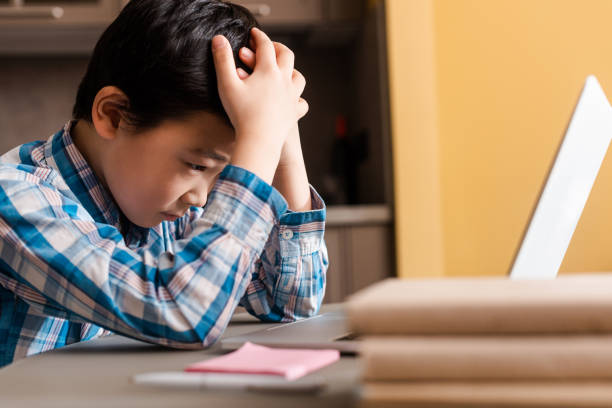 istock sad asian boy studying online with laptop at home during quarantine 1250176307