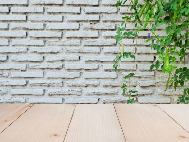 istock Wooden board empty table top on of white brick wall background. 1250177339