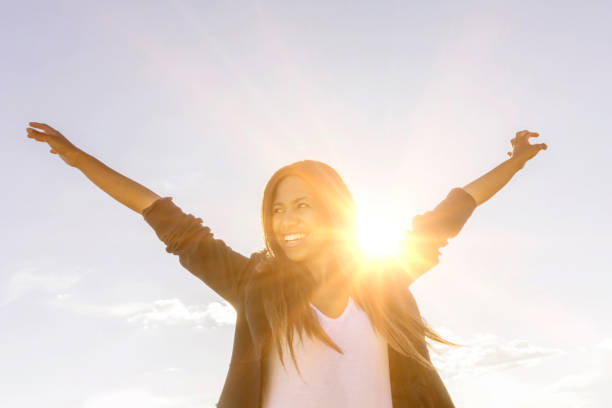 Happy woman enjoying the sunshine outdoors Portrait of a happy African American woman enjoying the sunshine outdoors and smiling spiritual enlightenment stock pictures, royalty-free photos & images