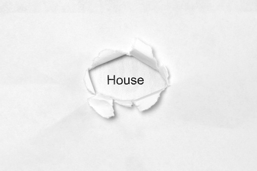 Word House on white isolated background, the inscription through the wound hole in paper. Stock photo for web and print with empty space for text