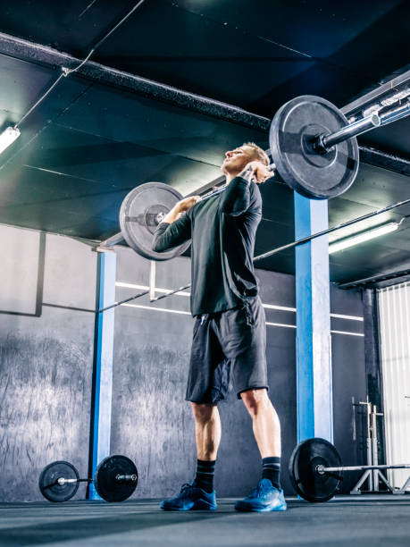 クロストレーニングジムでバーベルを持ち上げる男性アスリート - weightlifting crossfit weight training men ストックフォトと画像