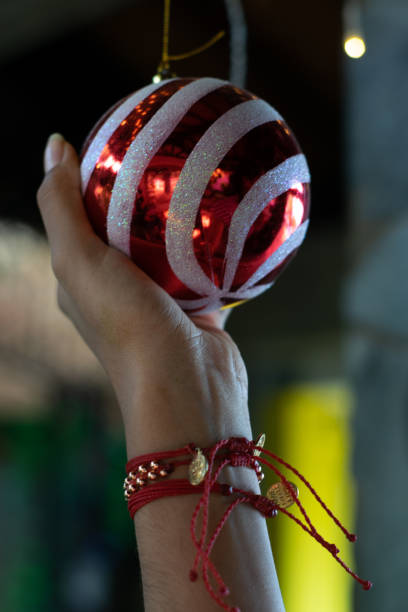 istock woman hand holding red christmas sphere 1250181516