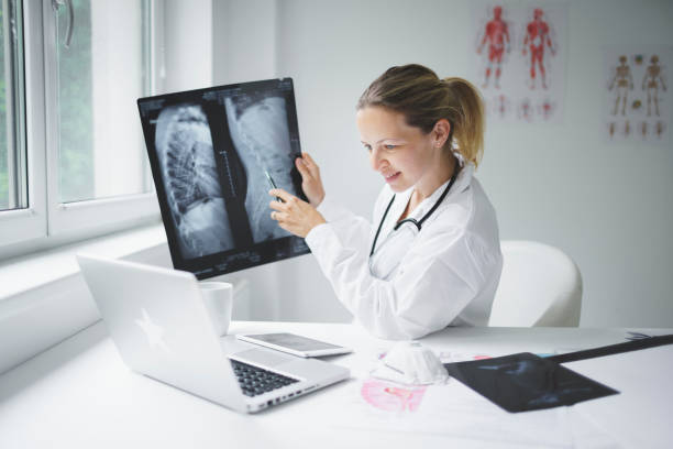 istock pretty doctor discusses X-ray image online with her patient 1250184723