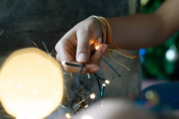 istock woman hand with yellow christmas lights 1250186604