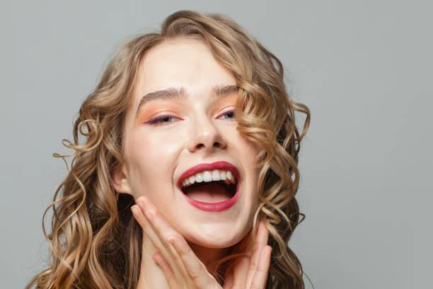 istock Young woman laughing on gray background 1250187031
