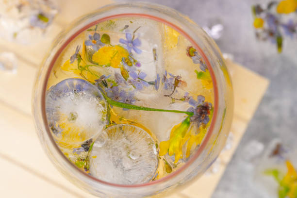 istock Champagne cocktail with ice and flowers on a light gray background. 1250189794
