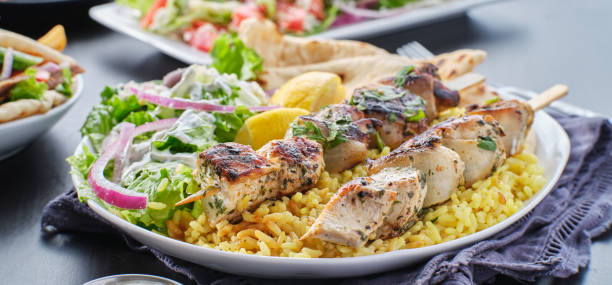 greek chicken souvlaki platter with pita bread, salad and rice - souvlaki imagens e fotografias de stock