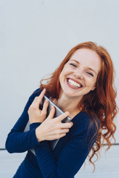 istock Young cheerful woman holding digital tablet 1250191768