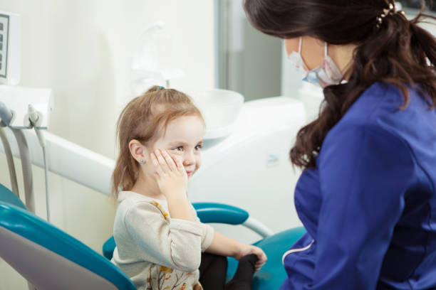 istock kid sits at dentist office and holds cheek 1250193438