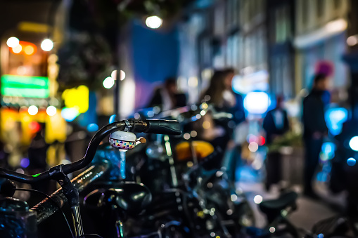 Parking for bicycles at night with city at blurred background