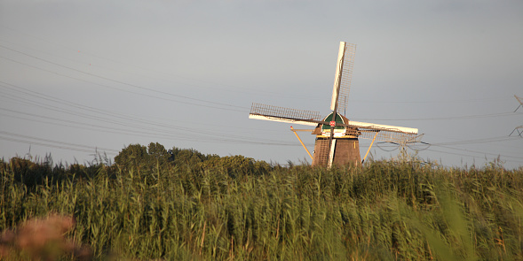 A pretty windmill sits in a rural setting.