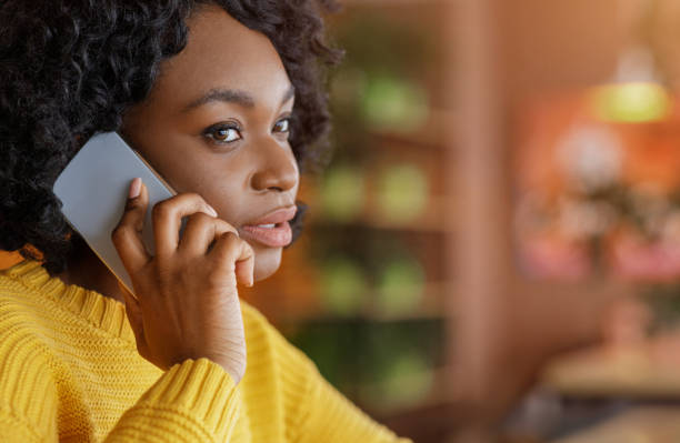 istock Black woman talking on mobile phone, cafe interior 1250195682