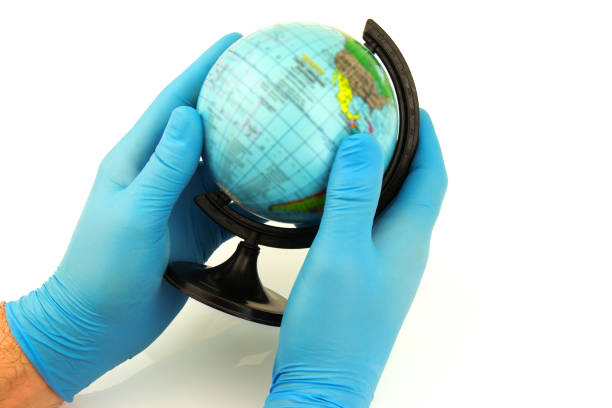 istock Hands with blue rubber gloves holding globe 1250195866