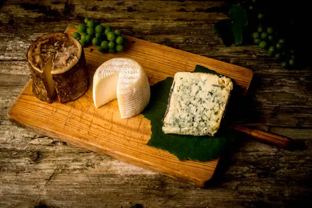 Photo of Three varieties of artisan cheese from northern Spain on a wooden table