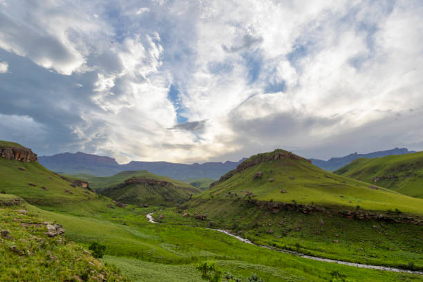 istock Clouds in late afternoon light above green valley and mountains 1250199968