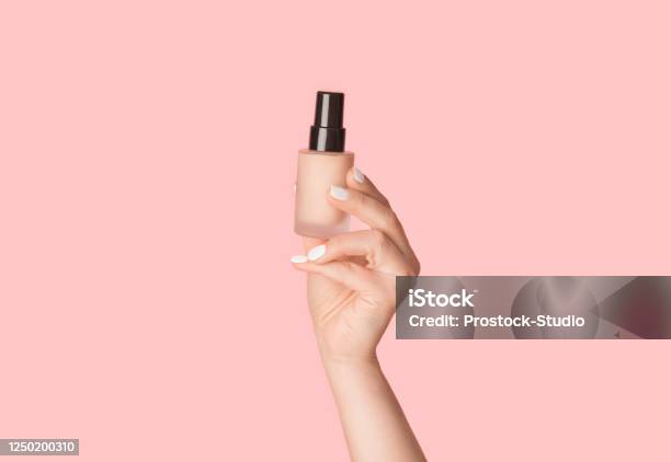 Skin Care Concept Millennial Lady Holding Bottle Of Natural Concealer On Pink Background Closeup Stock Photo - Download Image Now