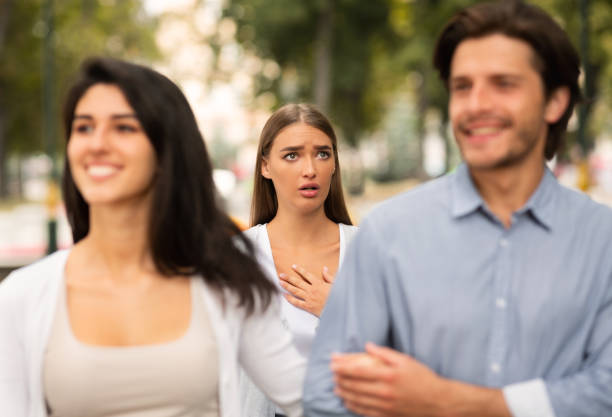 Girl Meeting Her Boyfriend Dating With Other Woman Walking Outside Cheating Boyfriend. Desperate Girl Meeting Her Man Dating With Other Woman Walking Outside In Park. Selective Focus former photos stock pictures, royalty-free photos & images