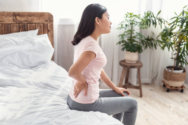 istock Asian Lady Suffering From Pain In Back Sitting On Bed 1250203804