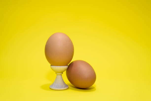istock Two brown eggs isolated on the yellow background. 1250206567