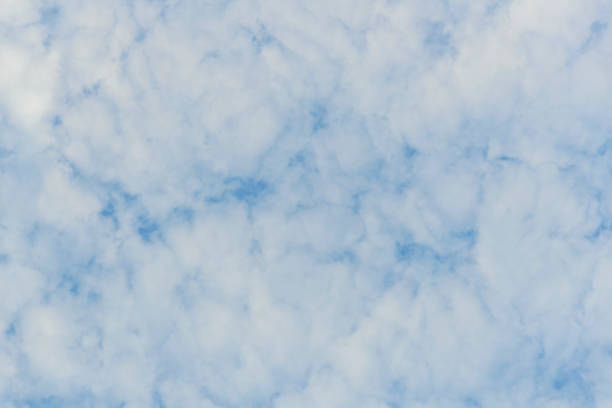 Soft overhead clouds in the blue sky during a springtime evening. Suitable as background image.