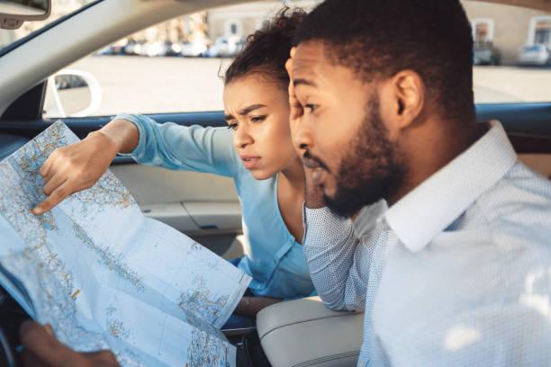 istock Couple Looking At Map During Car Trip Sitting In Automobile 1250208462
