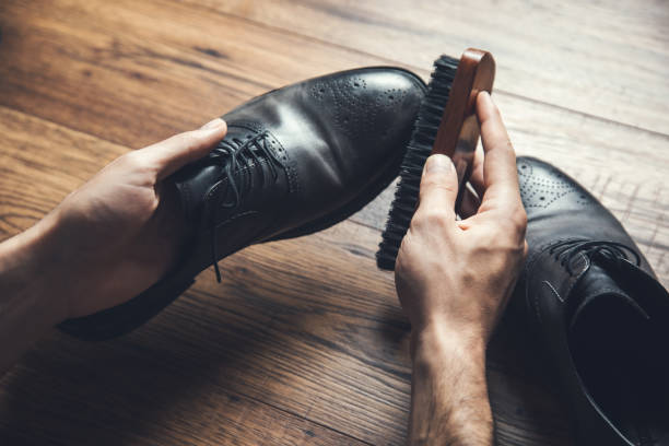 istock man hand brush and shoes 1250208695