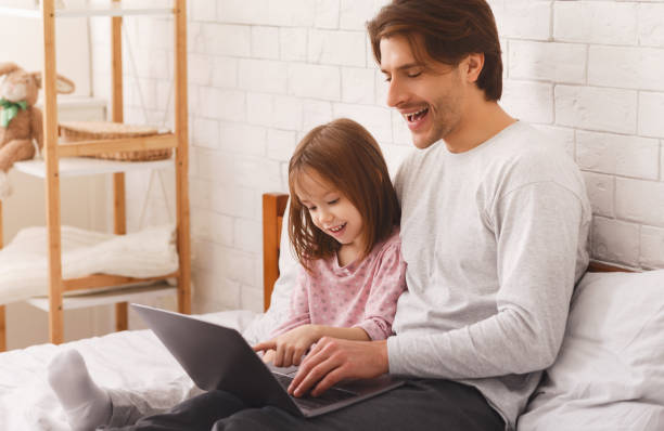 istock Preschool girl spending time with her dad, using laptop 1250208784