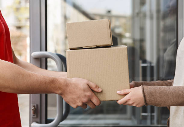 istock Guaranteed excellent service. Hands of client and courier are holding parcels 1250208931