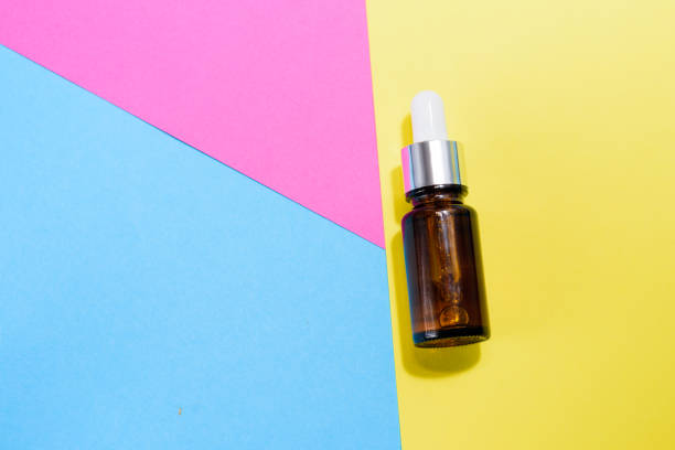 istock A cosmetic jar with glass dropper on the multi colored background. 1250210322