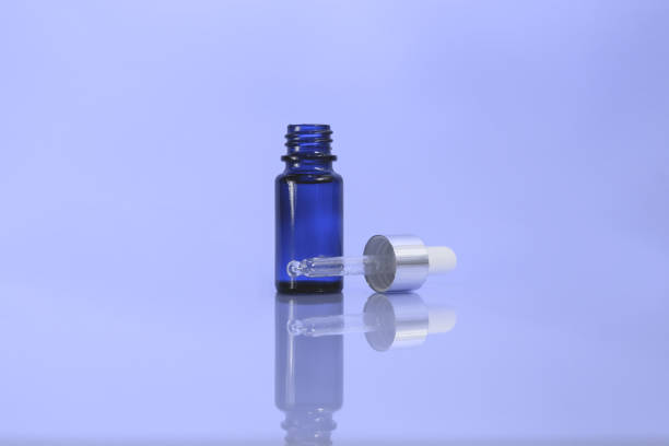 istock A cosmetic jar with glass dropper on the blue background. 1250210422