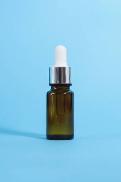 istock A cosmetic jar with glass dropper on the blue background. 1250210886