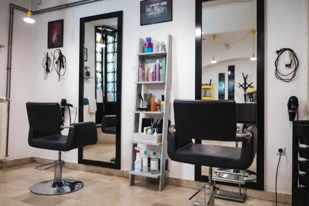 Photo of Empty hair salon interior with chairs and mirrors.